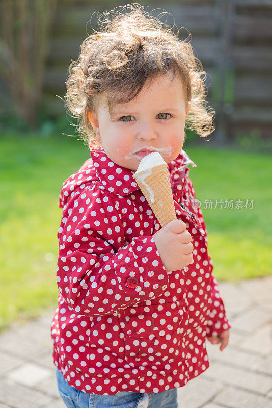 甜美的女孩在户外吃冰淇淋