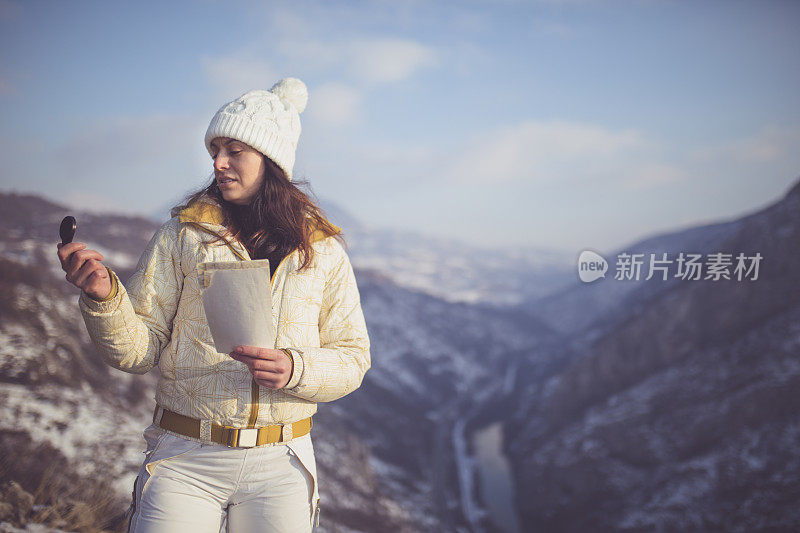 徒步旅行的妇女在山中阅读地图。