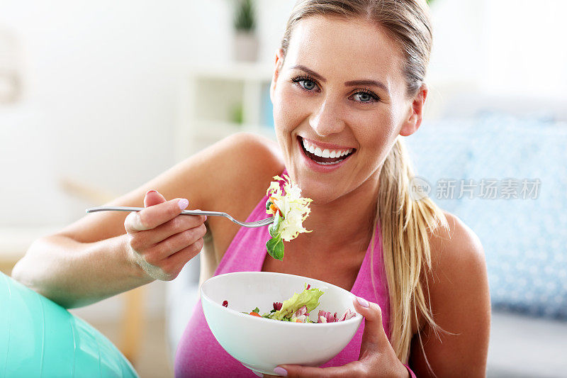 年轻女子在锻炼后吃健康的沙拉