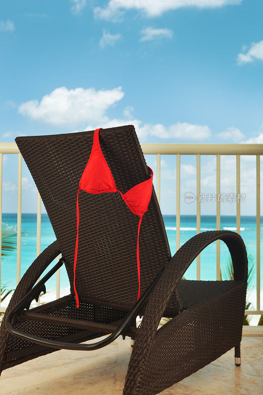 红色比基尼晾在热带海滩度假酒店阳台上