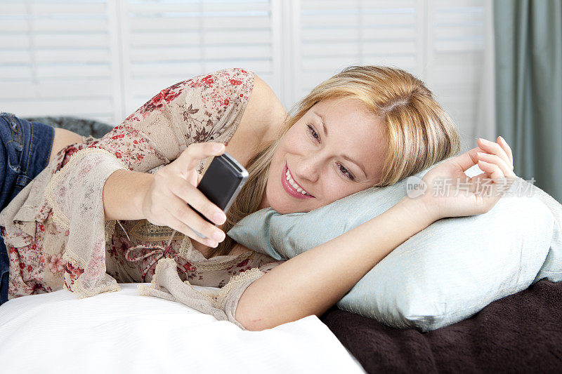 少女在床上用智能手机放松
