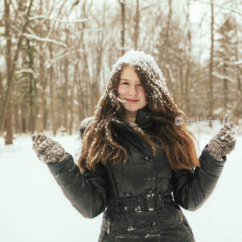 十几岁的长发女孩玩雪