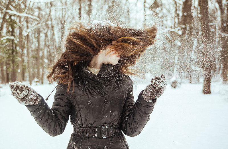 十几岁的长发女孩玩雪