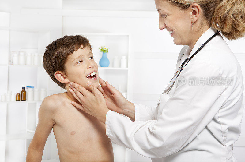 儿科医生友好地检查小男孩的喉咙扁桃体