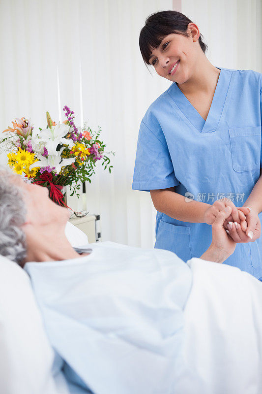 护士握着老病人的手