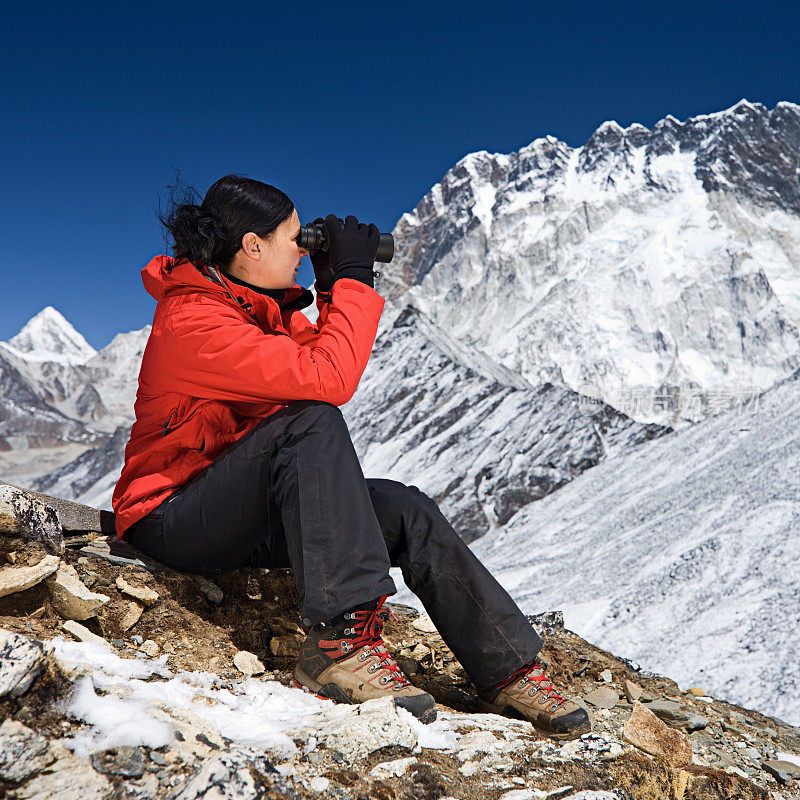 在珠穆朗玛峰国家公园，一名妇女正在用双筒望远镜看东西