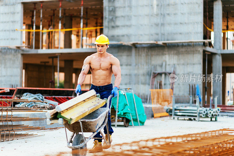 强壮、肌肉发达的手工建筑工人在施工平台上工作