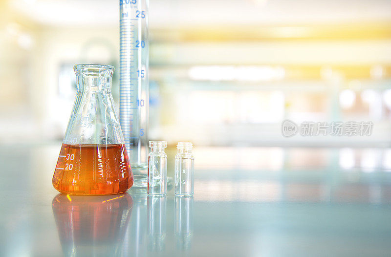 有化学实验室背景的瓶状小瓶玻璃烧瓶中的橙色液体