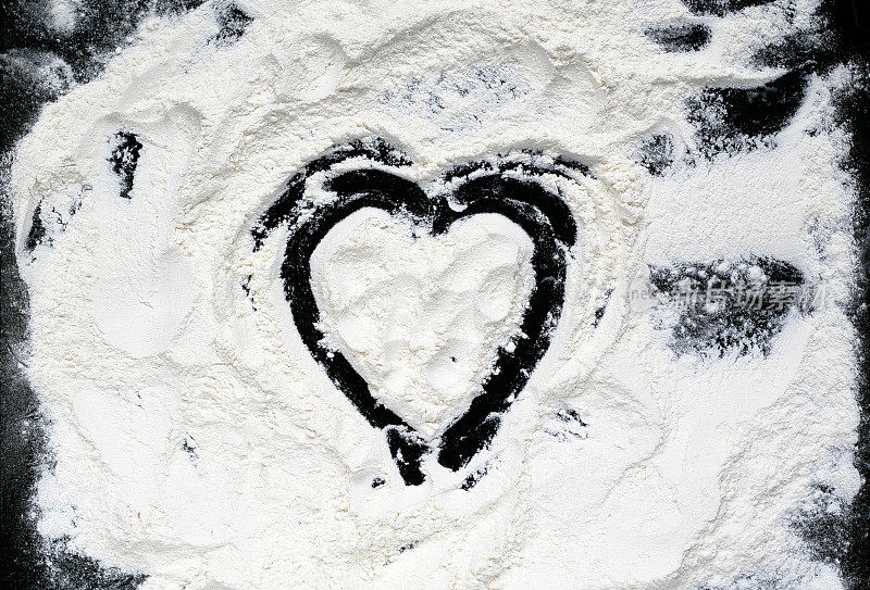 心画在白色面粉的背景上，放在黑色的桌子上