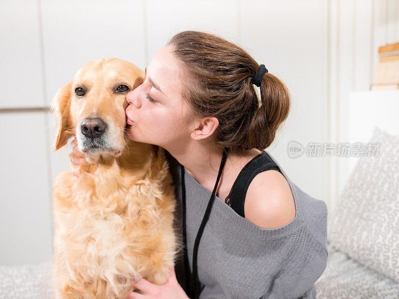 年轻女子抱着并亲吻她的狗