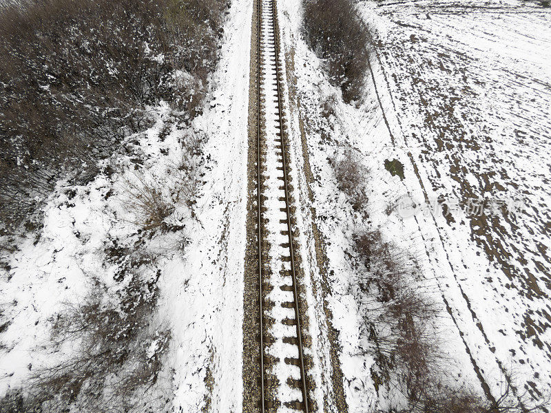 古老的铁路穿越雪域的冬季自然景观。鸟瞰图。