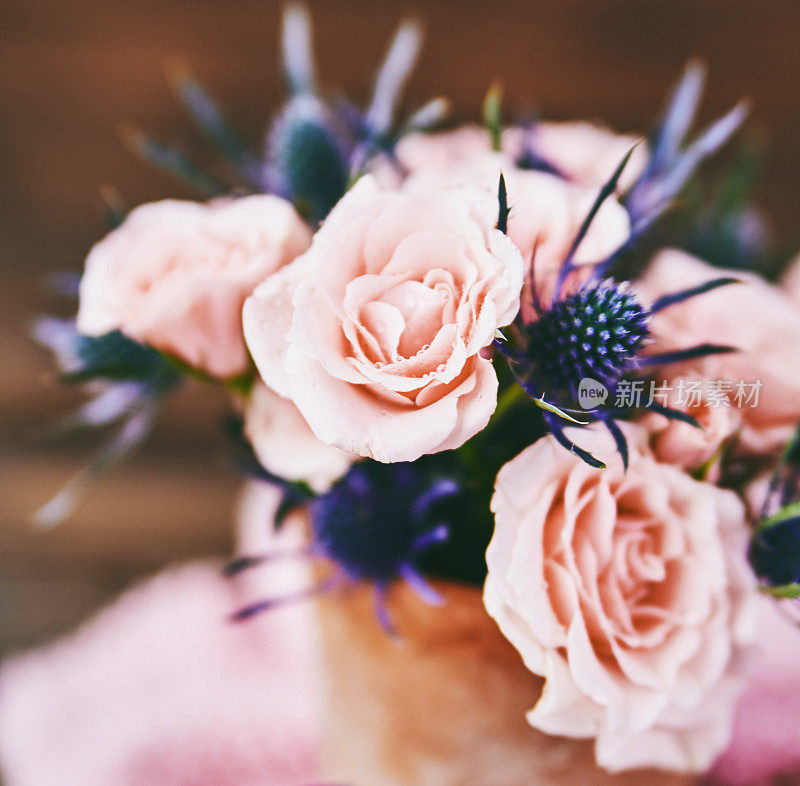 质朴的陶瓷花瓶里的母亲节花束，上面有粉红色的玫瑰