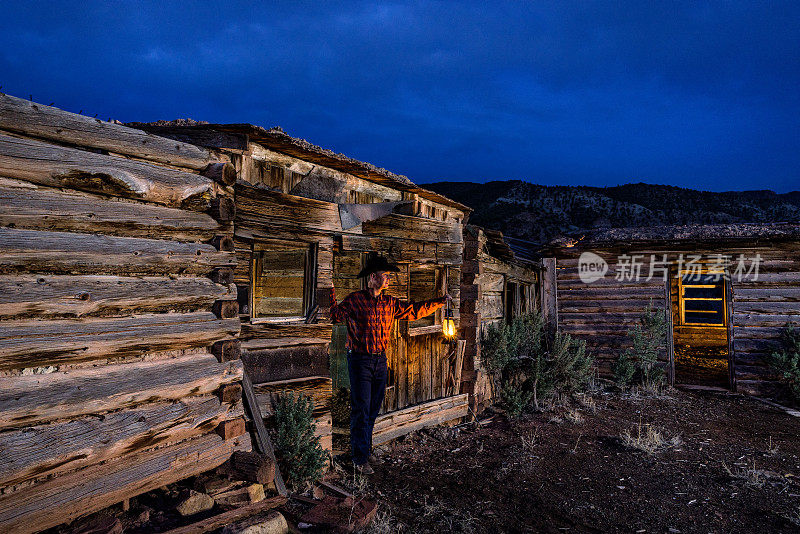 黄昏时分，牛仔在鬼城的小木屋里举着发光的灯笼