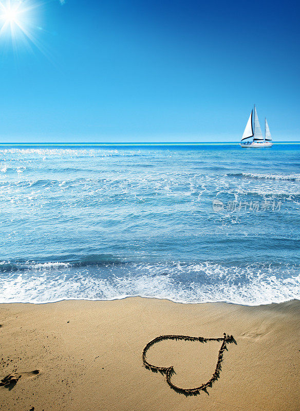 在晴朗的天空下，有心形的沙滩和帆船在地平线上
