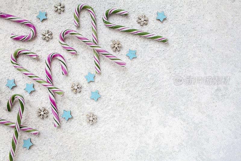 糖果拐杖与星星和雪花装饰在一个轻纹理表面直接向上看