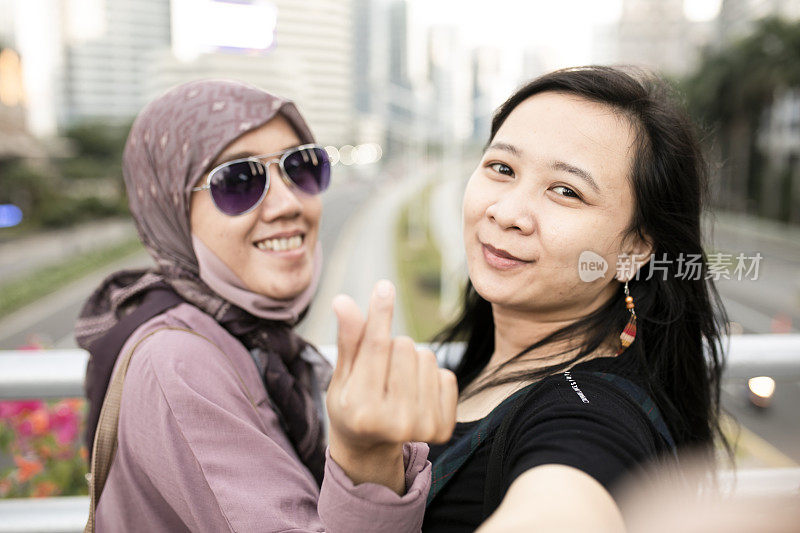 亚洲旅行者用手机在城市中行走和拍照
