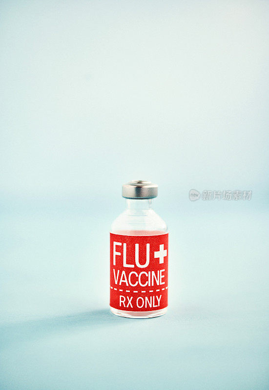 亮蓝色背景的流感疫苗小瓶
