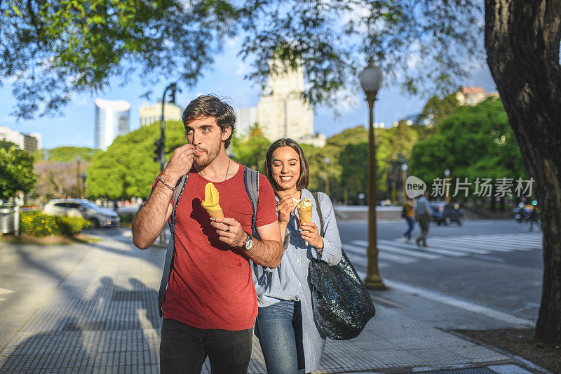 年轻游客在阳光明媚的布宜诺斯艾利斯吃冰淇淋