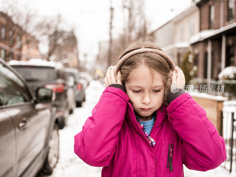 白雪覆盖的城市街道上的年轻女孩