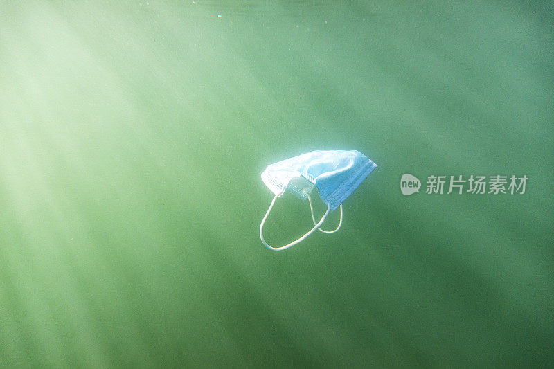 一次性口罩污染漂浮在浑浊的海水中