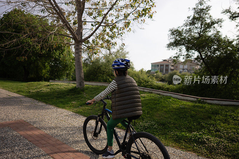 快乐的男孩在公园里骑自行车