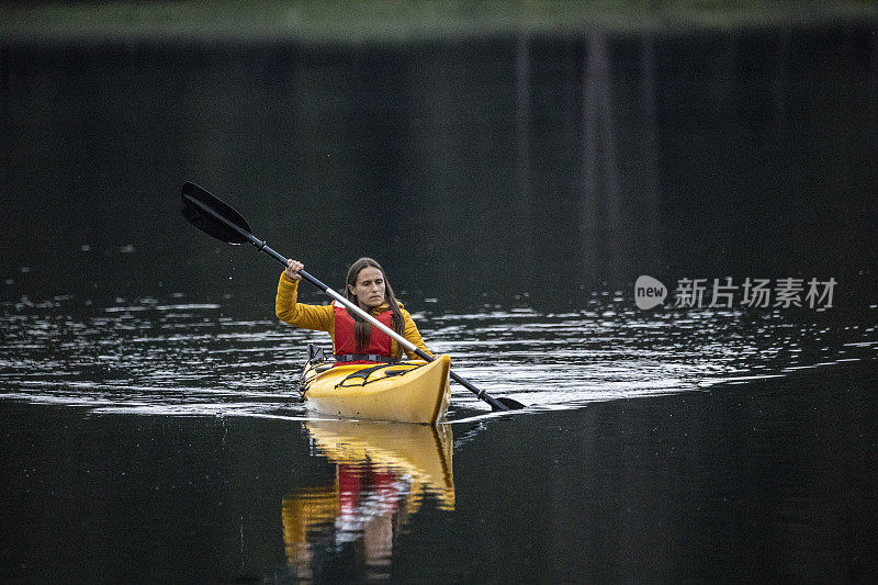 皮划艇和生态旅游。女子划水在山湖，鸟瞰。