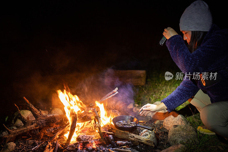 女营员在露天营火上做饭