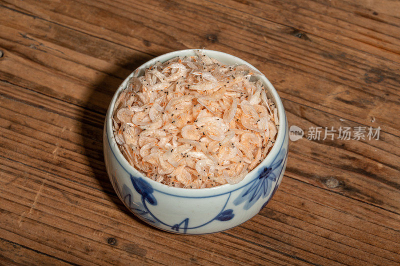 碗或盘子里的干虾子放在木桌上。