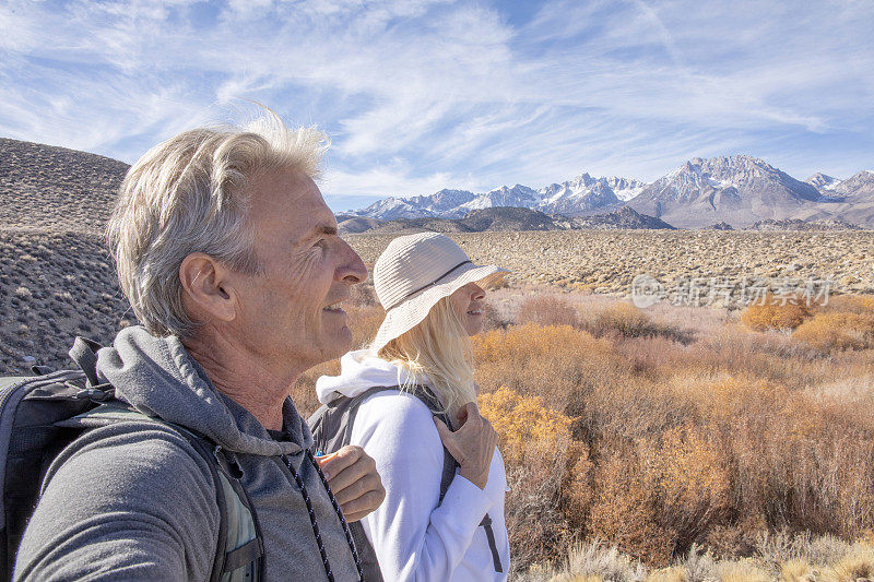 一对徒步旅行的夫妇沿着小路穿过干旱的沙漠