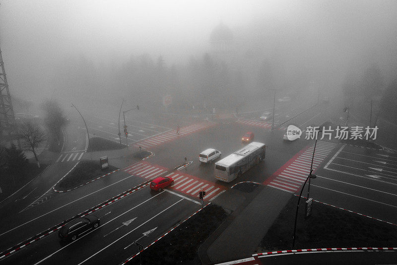 高视角的汽车行驶在繁忙的十字路口在晨雾