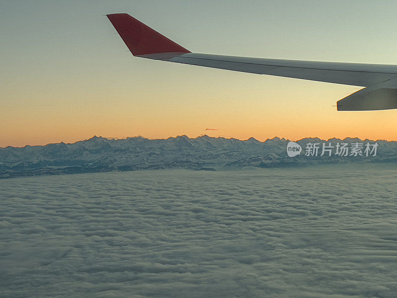 从飞机窗口往外看，美丽的日出在空中