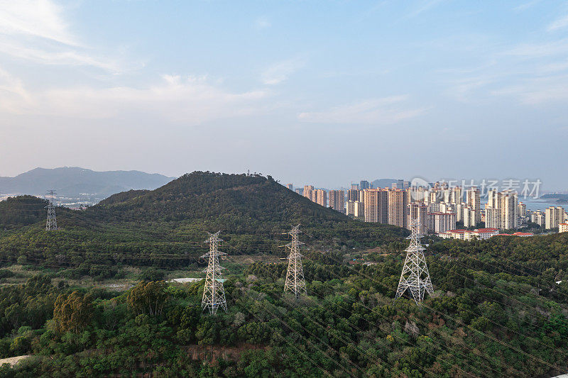 在城市边缘的山上有一座高压输电塔