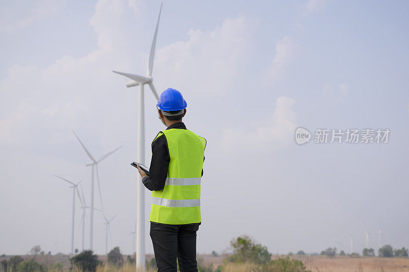 在发电厂工作的蓝领工人。风车。