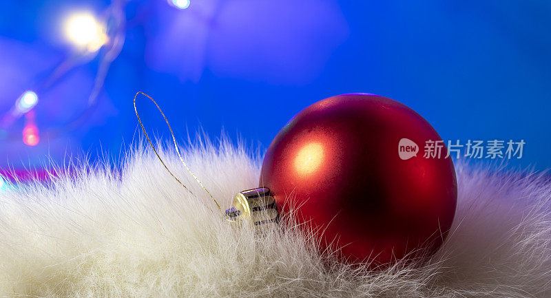 红色球圣诞装饰上的蓝色背景。圣诞节灯泡。