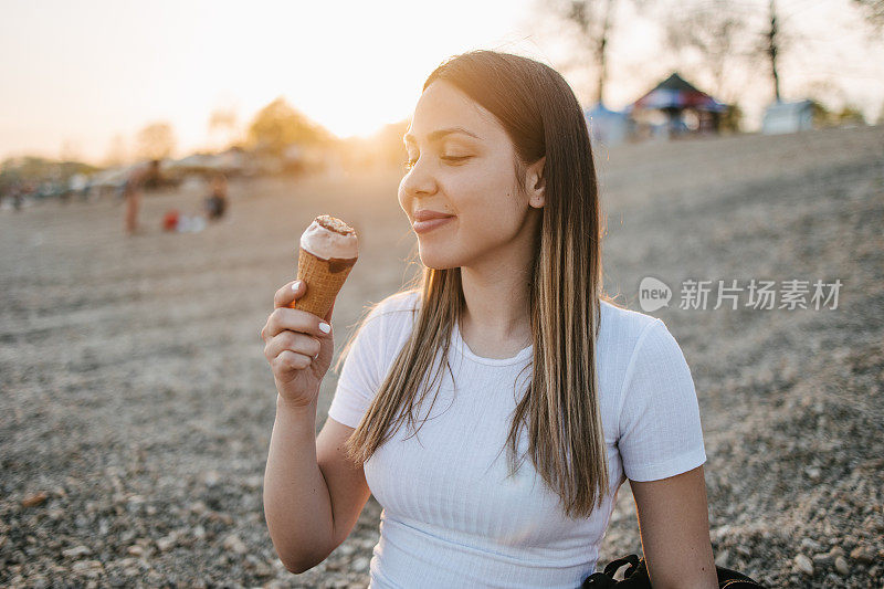 拿着背包吃冰淇淋的女人