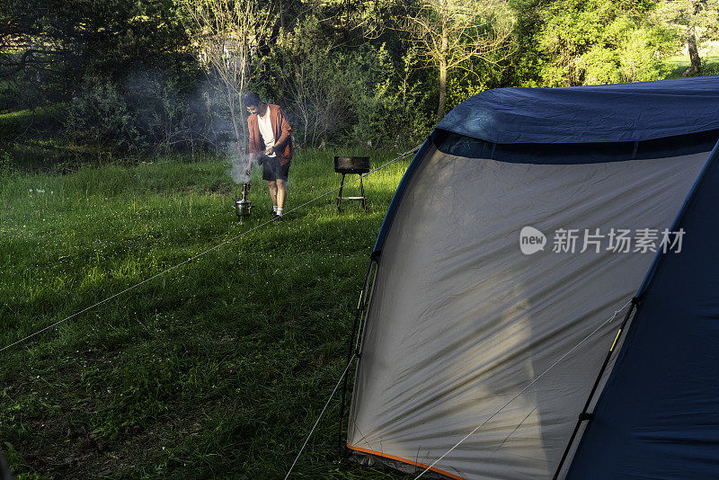 一个在森林里露营的人正在烧烤。