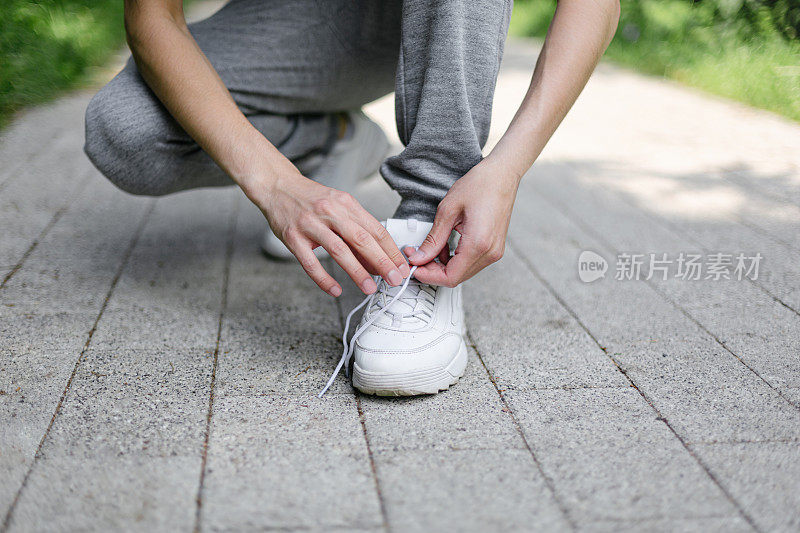 特写镜头的手系鞋带运动鞋。准备慢跑。