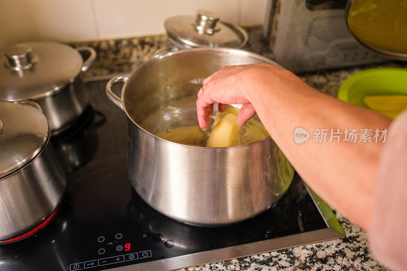 一个女人正在平底锅里放削了皮的土豆