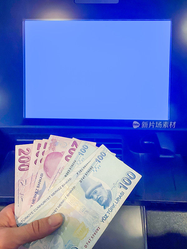 自动柜员机存取土耳其里拉。手持土耳其里拉的黑屏ATM机(有裁剪路径的屏幕)