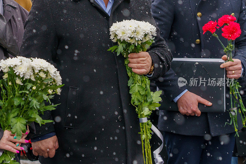 在大雪纷飞的严冬，在庄严的安葬仪式或追悼日，手持鲜花