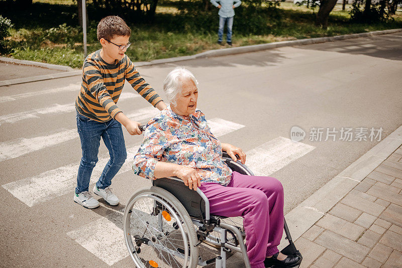 小孩在轮椅上照顾过马路的爷爷奶奶