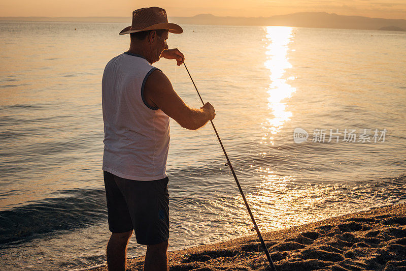 爱好，一个男人正在海边用鱼竿钓鱼