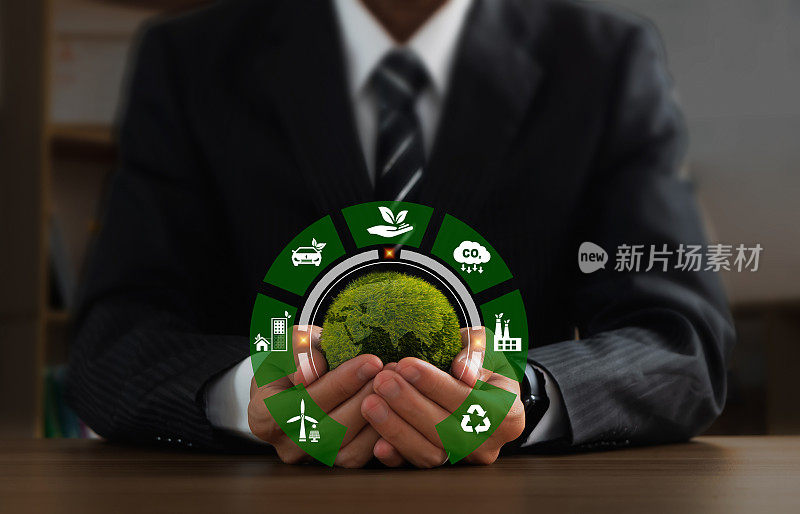 商人手持绿色地球，绿色商业的标志为ESG，二氧化碳和净零。可持续发展的概念，可持续发展目标，绿色技术，世界地球日和环境技术。