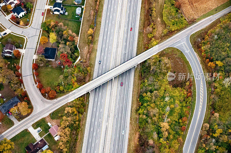 多车道州际公路鸟瞰图，其中有一个州际公路立交桥通往一个小区