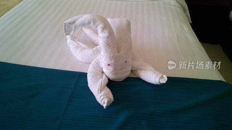 从旅馆床上的毛巾上折叠起来的小雕像