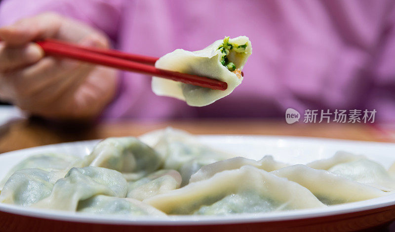 女人的手拿起一个饺子