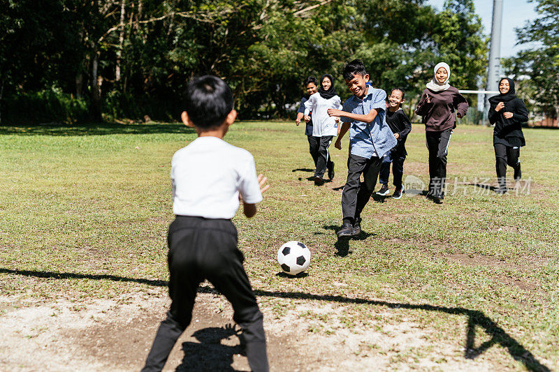 小学生在校园里踢足球