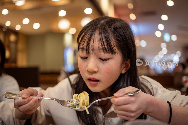 十几岁的女孩在餐厅吃意大利面当午餐