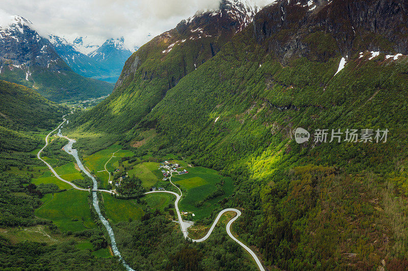 鸟瞰图汽车驾驶发夹路在风景秀丽的绿山山谷在挪威