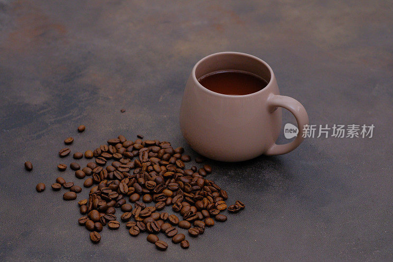 一杯咖啡和咖啡豆在深棕色的背景。